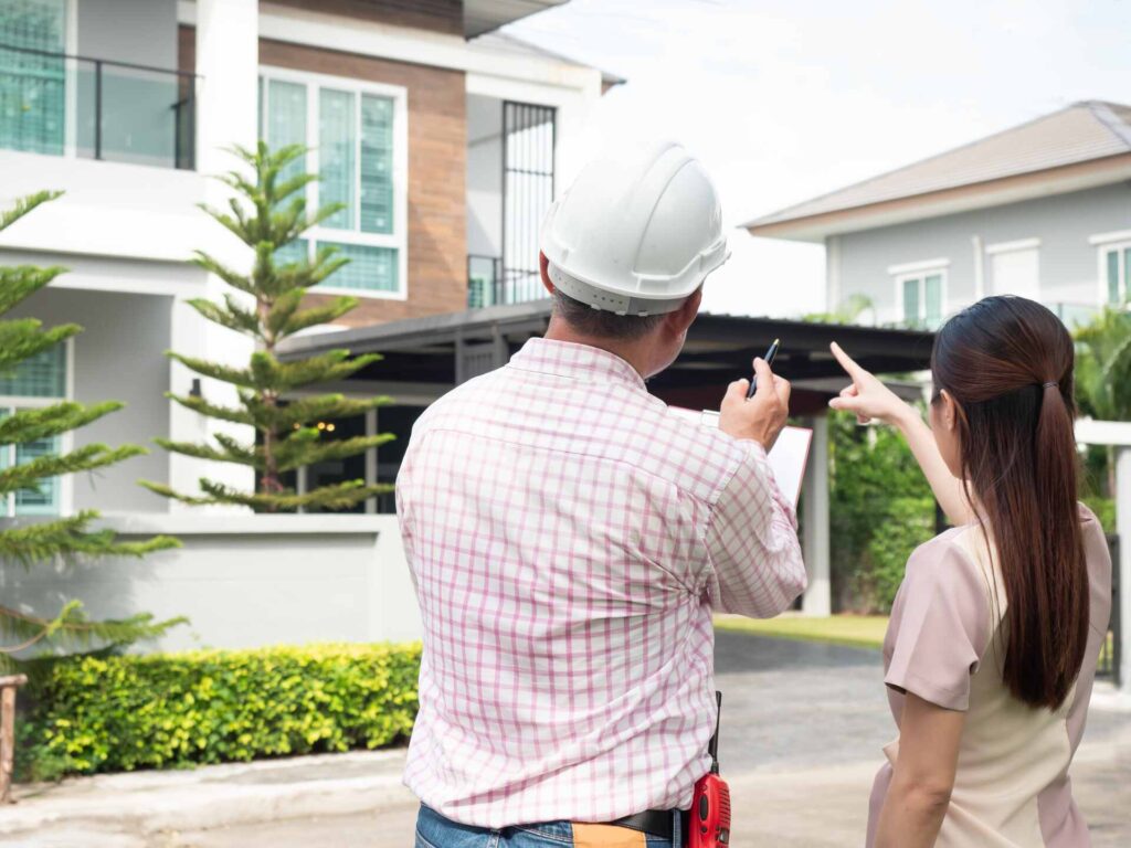 เจ้าของบ้านกำลังคุยกับผู้รับเหมา เพื่อตัดสินใจว่าจะต่อเติมบ้านที่ไหนดี