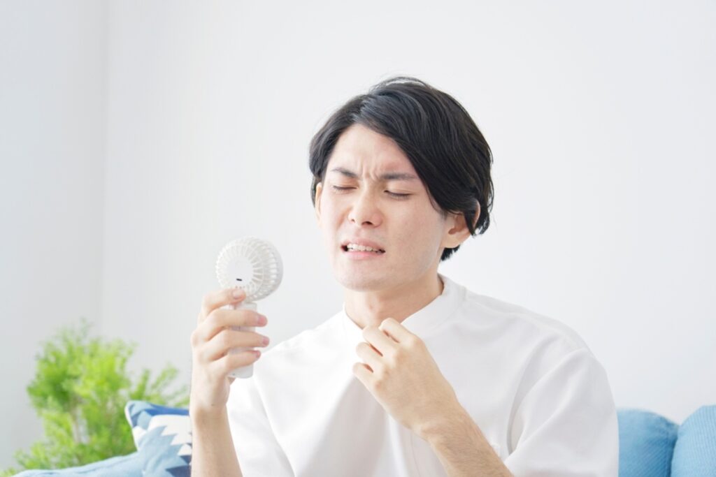 asian-man-using-portable-fan-home