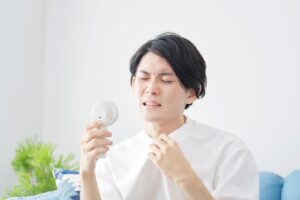 asian-man-using-portable-fan-home